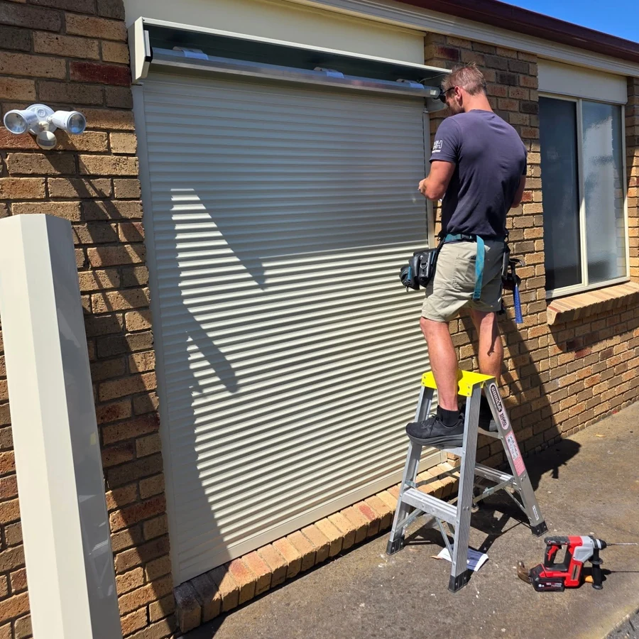 A Bay City Blinds installer fitting a roller shutter at a Geelong home